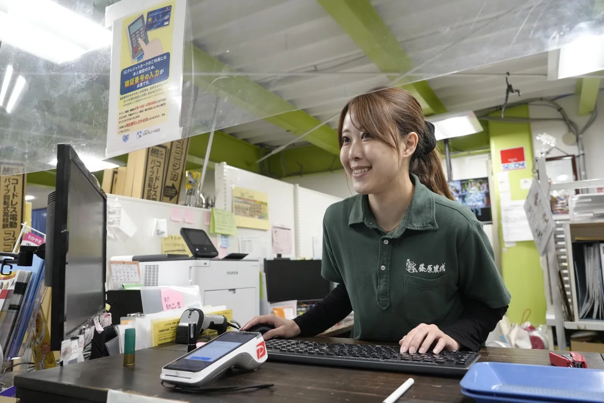 藤原農機の店舗カウンターで接客する社員
